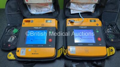 2 x Medtronic Physio Control Lifepak 1000 Defibrillators (Both Power Up with Cracks in Casing - See Photos) with 2 x 3 Lead ECG Leads, 3 x Electrode Packs (All in Date) and 2 x Batteries *Install Before 2024 / 2024* - 2