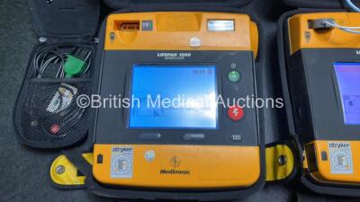 2 x Medtronic Physio Control Lifepak 1000 Defibrillators (Both Power Up with Cracks in Casing - See Photos) with 2 x 3 Lead ECG Leads, 3 x Electrode Packs (All in Date) and 2 x Batteries *Install Before 2024 / 2024* - 3