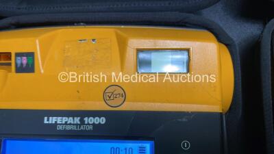 2 x Medtronic Physio Control Lifepak 1000 Defibrillators (Both Power Up with Cracks in Casing - See Photos) with 2 x 3 Lead ECG Leads, 3 x Electrode Packs (All in Date) and 2 x Batteries *Install Before 2024 / 2024* - 4