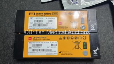 2 x Medtronic Physio Control Lifepak 1000 Defibrillators (Both Power Up with Cracks in Casing - See Photos) with 2 x 3 Lead ECG Leads, 4 x Electrode Packs (3 in Date, 1 x Expired) and 2 x Batteries *Install Before 2022 / 2025* - 7