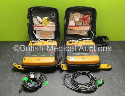 2 x Medtronic Physio Control Lifepak 1000 Defibrillators (Both Power Up with Cracks in Casing - See Photos) with 2 x 3 Lead ECG Leads, 4 x Electrode Packs (All in Date) and 2 x Batteries *Install Before 2022 / 2025*