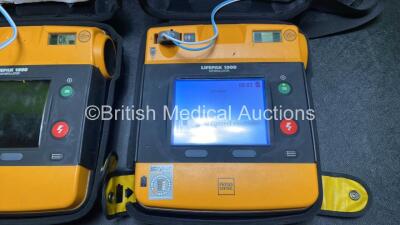 2 x Medtronic Physio Control Lifepak 1000 Defibrillators (Both Power Up with Cracks in Casing - See Photos) with 2 x 3 Lead ECG Leads, 4 x Electrode Packs (All in Date) and 2 x Batteries *Install Before 2022 / 2025* - 5