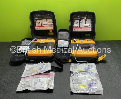 2 x Medtronic Physio Control Lifepak 1000 Defibrillators (Both Power Up, 1 x Small Crack in Casing, 1 x Slight Damage to Casing - See Photos ) with 2 x 3 Lead ECG Leads, 4 x Electrode Packs (All in Date) and 2 x Batteries *Install Before 2028 / 2024*