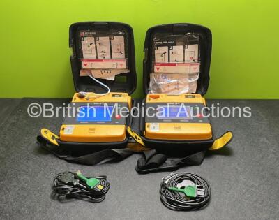 2 x Medtronic Physio Control Lifepak 1000 Defibrillators (Both Power Up with Cracks in Casing - See Photos) with 2 x 3 Lead ECG Leads, 4 x Electrode Packs (3 in Date, 1 x Expired) and 2 x Batteries *Install Before 2024 / 2028*