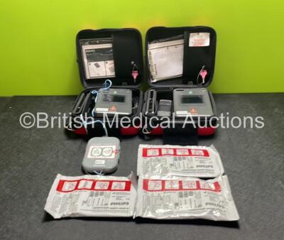 2 x Philips Heartstart FR3 Defibrillators (Both Power Up) In Carry Cases with 4 x Electrode Packs (All in Date) and 2 x Batteries (Install Before 2028 / 2028) *SN C18B-00119 / C18B-00083*