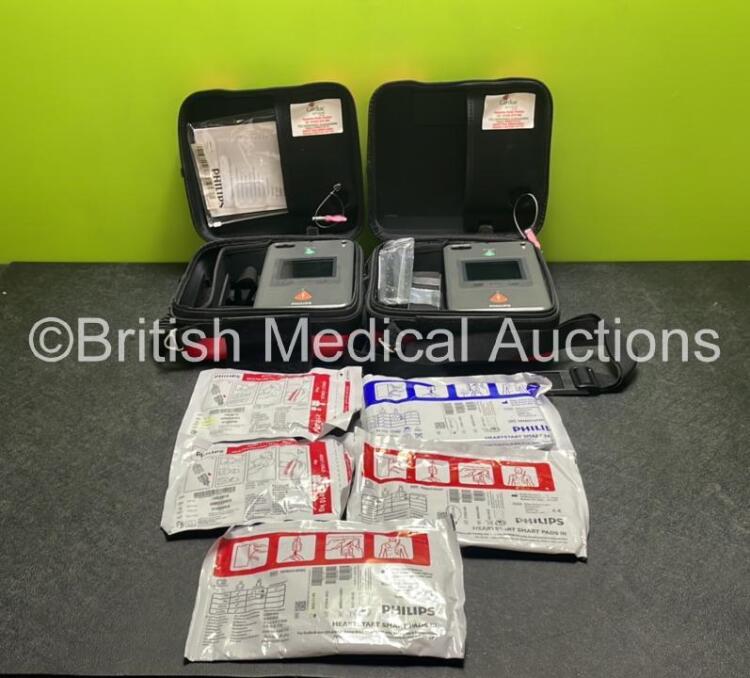 2 x Philips Heartstart FR3 Defibrillators (Both Power Up) In Carry Cases with 5 x Electrode Packs (4 in Date, 1 Expired) and 2 x Batteries (Install Before 2028 / 2028) *SN C18B-00096 / C19D-00199*