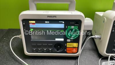 2 x Philips Efficia DFM100 Defibrillator *Mfd 2018 / 2020* with ECG and Printer Options, 2 x Batteries, 2 x Paddle Leads and 2 x 3 Lead ECG Leads (Both Power Up) *SN CN CN32639900 / CN32618883* - 2