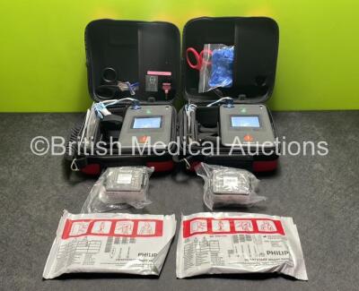 2 x Philips Heartstart FR3 Defibrillators (Both Power Up) In Carry Cases with 2 x Electrode Packs (1 in Date, 1 Expired) and 4 x Batteries (Install Before 2026 / 2028 / 2022 / 2023)