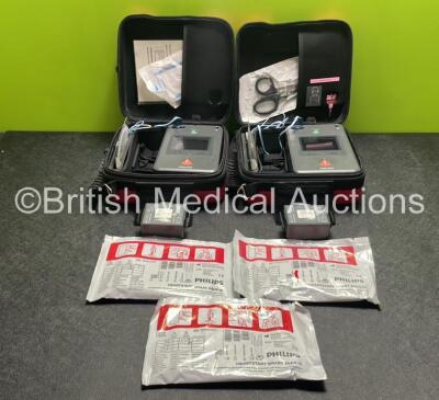 2 x Philips Heartstart FR3 Defibrillators (Both Power Up) In Carry Cases with 3 x Electrode Packs (All in Date) and 4 x Batteries (Install Before 2022 / 2022 / 2022 / 2025)