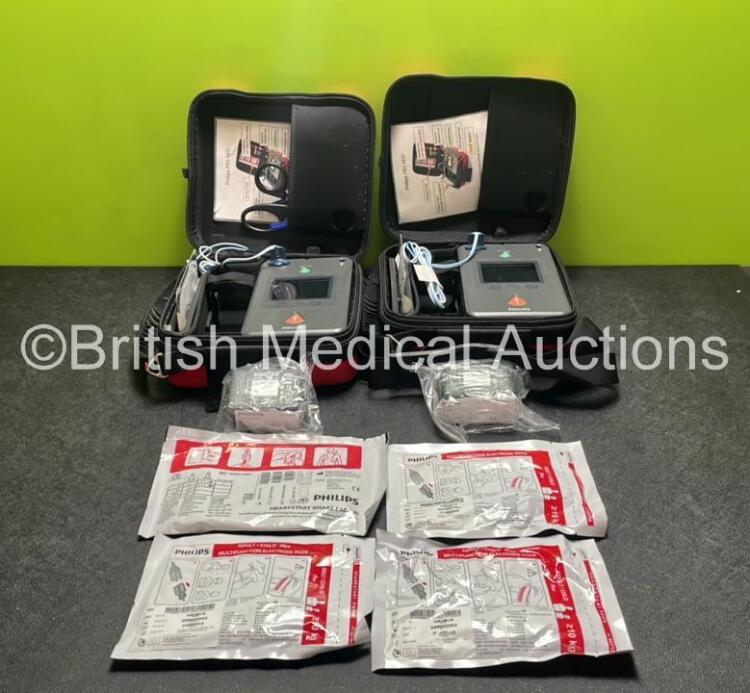 2 x Philips Heartstart FR3 Defibrillators (Both Power Up) In Carry Cases with 4 x Electrode Packs (All in Date) and 4 x Batteries (Install Before 2028 / 2028 / 2025 / 2025)