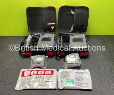 2 x Philips Heartstart FR3 Defibrillators (Both Power Up) In Carry Cases with 2 x Electrode Packs (Both Expired) and 4 x Batteries (Install Before 2028 / 2028 / 2024 / 2022)