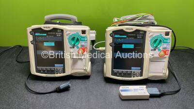 2 x Philips Heartstart MRx Defibrillators / Monitors Including ECG, and Printer Options (Both Power Up) with 1 x 3 Lead ECG Lead, 1 x Philips M3725A Test Load, 2 x Paddle Leads and 2 x Philips M3539A Modules