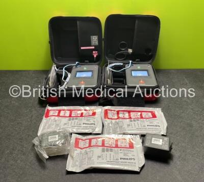 2 x Philips Heartstart FR3 Defibrillators (Both Power Up) In Carry Cases with 3 x Electrode Packs (All In Date) and 4 x Batteries (Install Before 2026 / 2026 / 2022 / 2027)