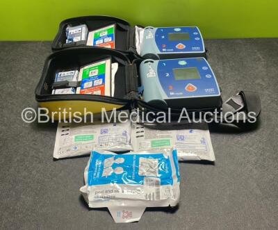 2 x Laerdal Heartstart FR2+ Defibrillators (Both Power Up) with 4 x Batteries and 3 x Electrode Packs *All in Date* in Carry Cases