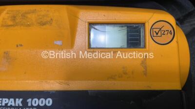 2 x Medtronic Physio Control Lifepak 1000 Defibrillators (Both Power Up with Cracks In Casing - See Photos) with 2 x ECG Leads, 2 x Electrode Packs (1 in Date, 1 Expired) and 2 x Batteries *Install Before 2025 / 2024* in Carry Cases - 3