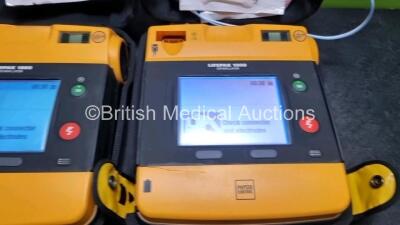 2 x Medtronic Physio Control Lifepak 1000 Defibrillators *Mfd - 2011 / 2014* (Both Power Up Both with Slight Crack In Casing - See Photos) - 2