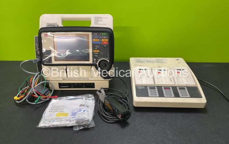 Medtronic Lifepak 12 Biphasic Defibrillator Including ECG, NIBP, Printer and SpO2 Options with 2 Batteries, 1 x ECG Lead, 1 x Test Load, 1 x Paddle Lead, 1 x Electrode Pack and 1 x Physio Control Battery Support System 2 with 3 x Batteries (Both Power Up)