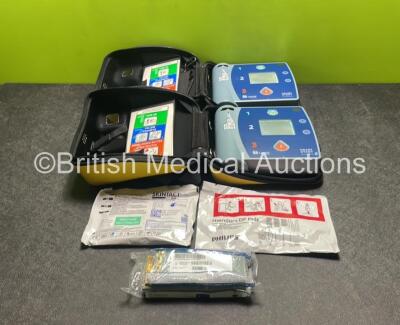 2 x Laerdal Heartstart FR2+ Defibrillators (Both Power Up) with 3 x Batteries and 2 x Electrode Packs *Both in Date* in Carry Cases