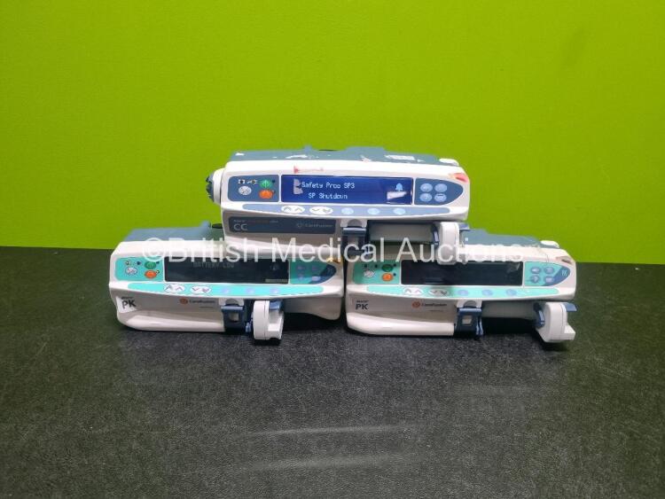 Job Lot Including 2 x Carefusion Alaris PK Syringe Pumps (1 x Powers Up 1 x Draws Power, 1 x with Damage to Casing - See Photo) and 1 x Carefusion Alaris Guardrails Plus CC Syringe Pump (Powers Up)