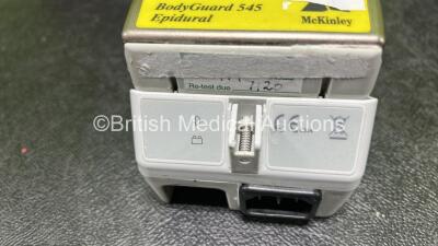 9 x McKinley 545 Bodyguard Epidural Infusion Pumps with 9 x Pump Chargers (8 x Power Up, 1 x No Power, 1 x Mark On Screen, 3 x Damaged Cases and 8 x Missing Batteries - See Photos) - 9